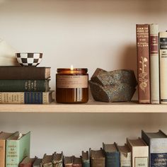 books and candles are sitting on the shelves