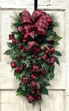 a red and black christmas wreath hanging on the side of a door