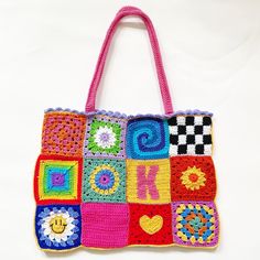 a multicolored crocheted bag with hearts, squares and letters on it