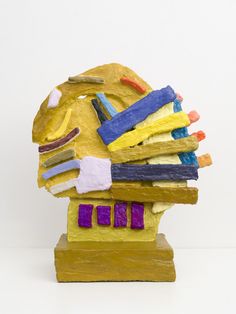 a yellow sculpture with different colored shapes on it