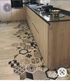 a kitchen with black and white tiles on the floor next to a stove top oven