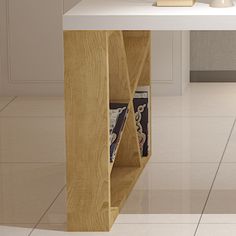 a white table with some books on it and a vase in the corner next to it