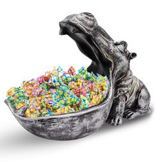 a dog statue sitting next to a bowl filled with sprinkles