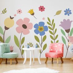 a child's room with flowers painted on the wall and two children's chairs