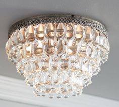 a crystal chandelier hanging from the ceiling in a room with gray walls and white trim