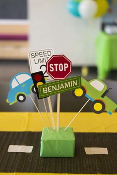 there is a stop sign and some cars on the table with sticks in front of it