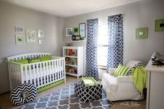 a baby's room decorated in green, white and gray with black curtains on the windows