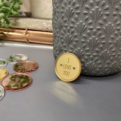 a close up of buttons on a table near a potted plant and a vase