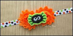 an orange headband with a black face and green eyes