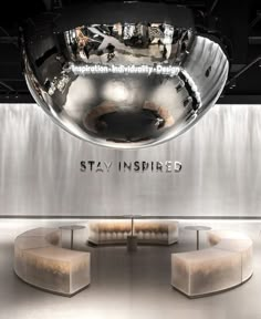 the inside of a showroom with two benches and a large mirror ball hanging from the ceiling