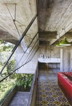 the interior of a concrete house with stairs leading up to an outdoor kitchen and dining area