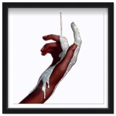 a person's hand with glitter on it holding something in their left hand, against a white background