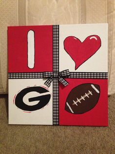 a wrapped canvas with footballs, heart, i love u and g on it