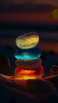 a stack of rocks sitting on top of each other in the sand at night time