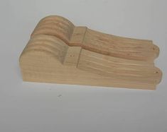 two pieces of wood sitting next to each other on a white surface with one piece missing