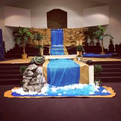 a cake made to look like a waterfall in the middle of a church with blue and gold decorations