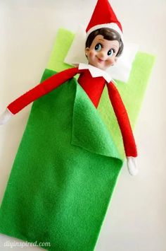 an elf is sitting on top of a green bag