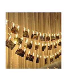 a string of lights hanging from the side of a curtain covered in pictures and photos