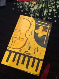 a yellow and black book with musical notes on it sitting next to a christmas tree