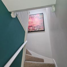 a painting is hanging on the wall above some stairs