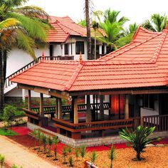 a house with red tile roofing and palm trees