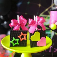 two small bags with bows on them sitting on a table next to a cupcake