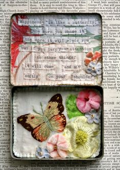 two small tins with flowers and butterflies in them on top of an open book