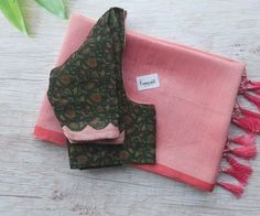 two pieces of pink and green cloth with tassels sitting on top of each other