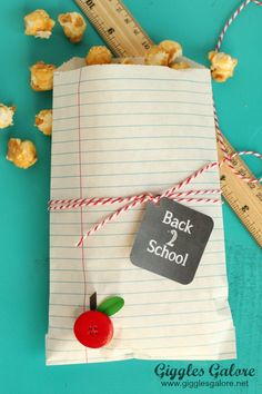 a back to school bag made out of paper with a red apple on it and a ruler next to it