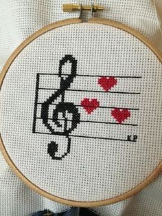 a cross stitch pattern with musical notes and hearts