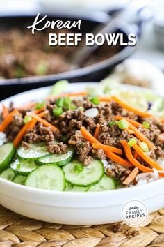 a white bowl filled with beef and cucumbers