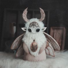 a white stuffed animal with black eyes and horns