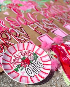 some paper plates sitting on the ground with pink and red decorations around them that spell out love