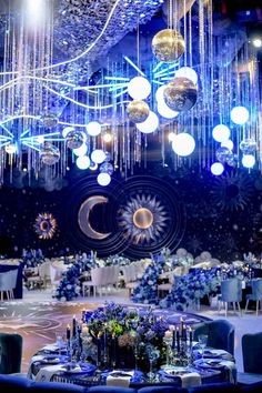 an elaborately decorated dining room with chandeliers and blue tables set for dinner