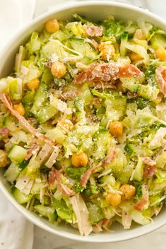 a white bowl filled with broccoli and chickpeas on top of a table