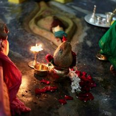 two women lighting candles on the ground in front of flowers and other items for diwaling