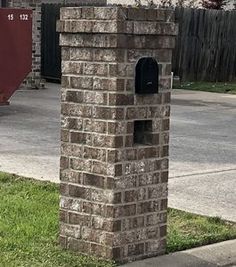 a brick mailbox sitting on the side of a road