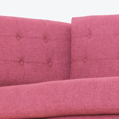 a pink couch sitting on top of a wooden floor