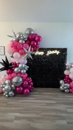 the balloon arch is decorated with pink, silver and white balloons