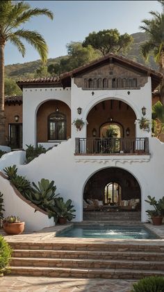 a large white house with steps leading up to the front door and pool area in front of it