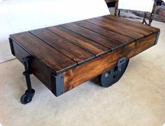 a wooden table with wheels on it in the middle of carpeted floor next to white wall