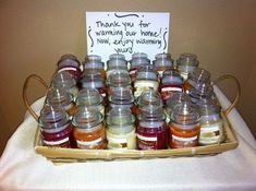 a basket filled with lots of jams on top of a white cloth covered table