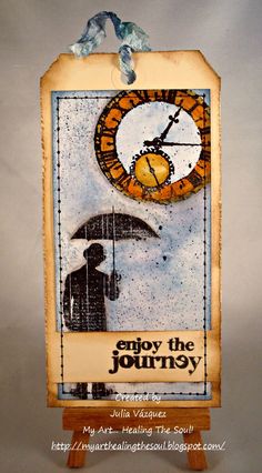 a small wooden sign with an image of a man holding an umbrella and the words enjoy the journey on it