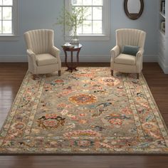 two chairs and a table in front of a window with a rug on the floor