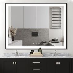 a bathroom vanity with a large mirror and lights on it's sides, along with two sinks