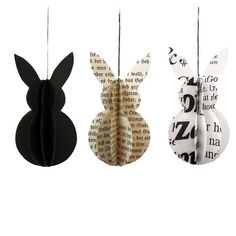 three paper rabbits hanging from strings with book pages in the shape of ears and tails