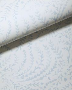 a white and blue wallpaper with leaves on it's side, next to a window