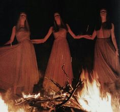 three women standing in front of a fire