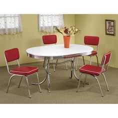 a white table with four red chairs and a flower vase on the top of it