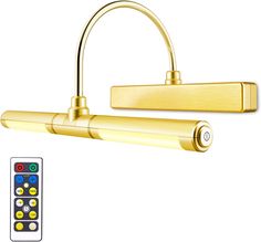 an image of a gold colored light fixture with remote control on the side and in front of it